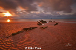Sunset over a shipwreck by Mike Clark 